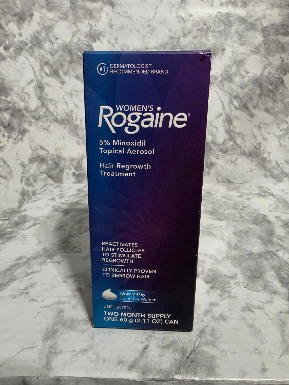 Box of Women's Rogaine hair regrowth treatment on a marble surface