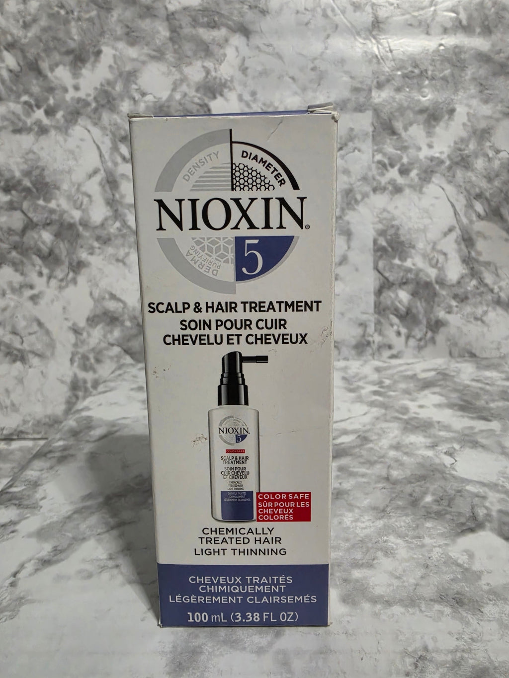 Nioxin hair treatment box on a marble surface