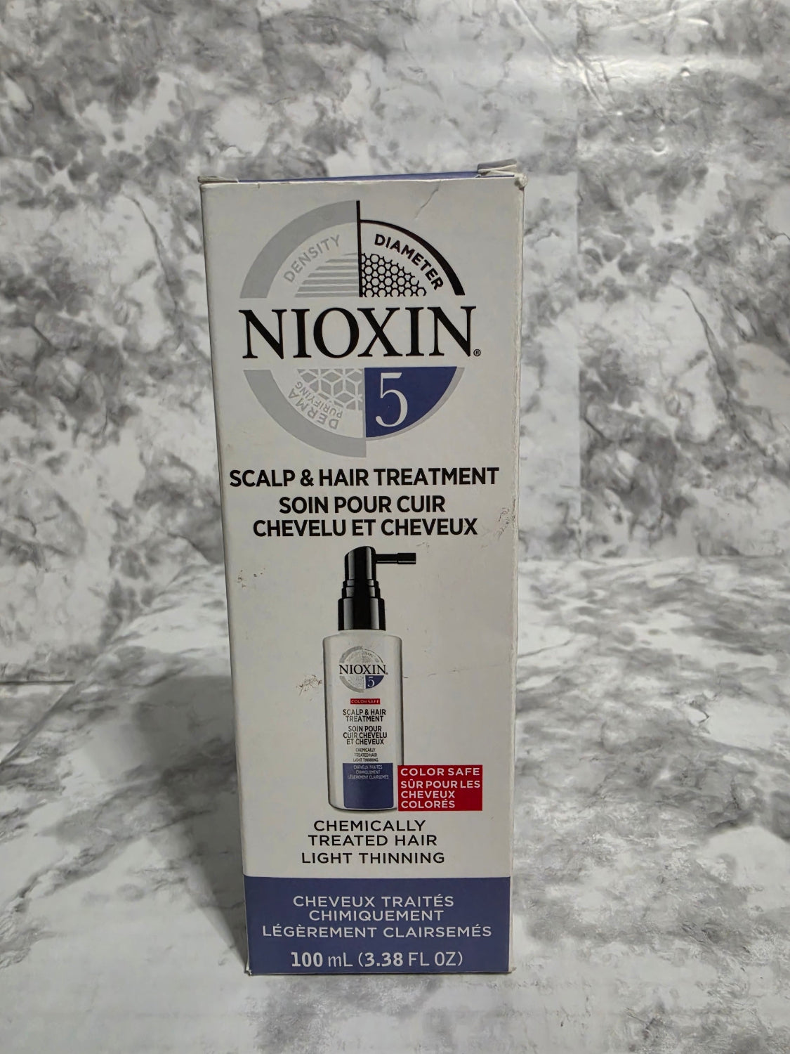 Nioxin hair treatment box on a marble surface