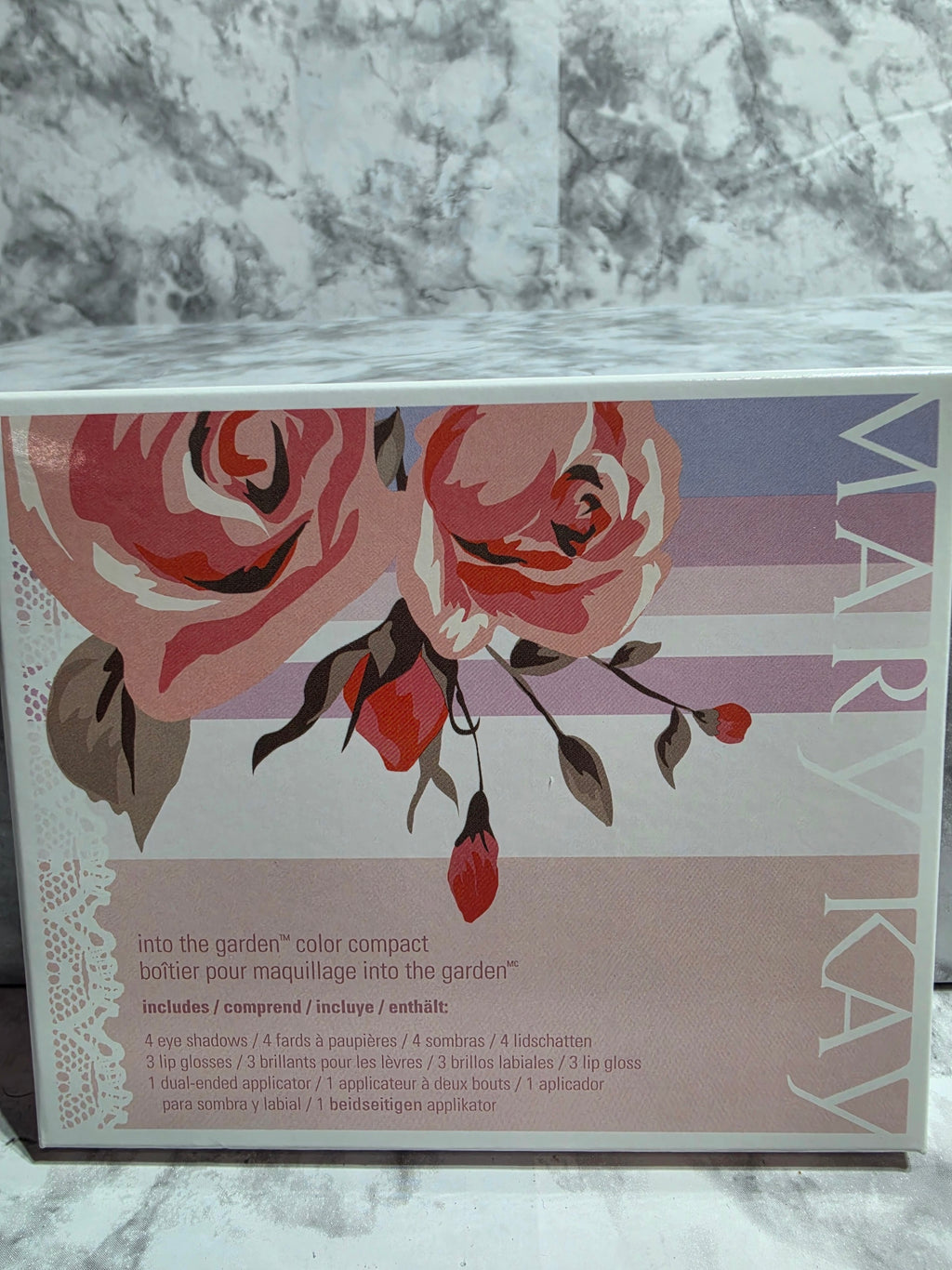 Mary Kay product packaging with floral design on a marble surface