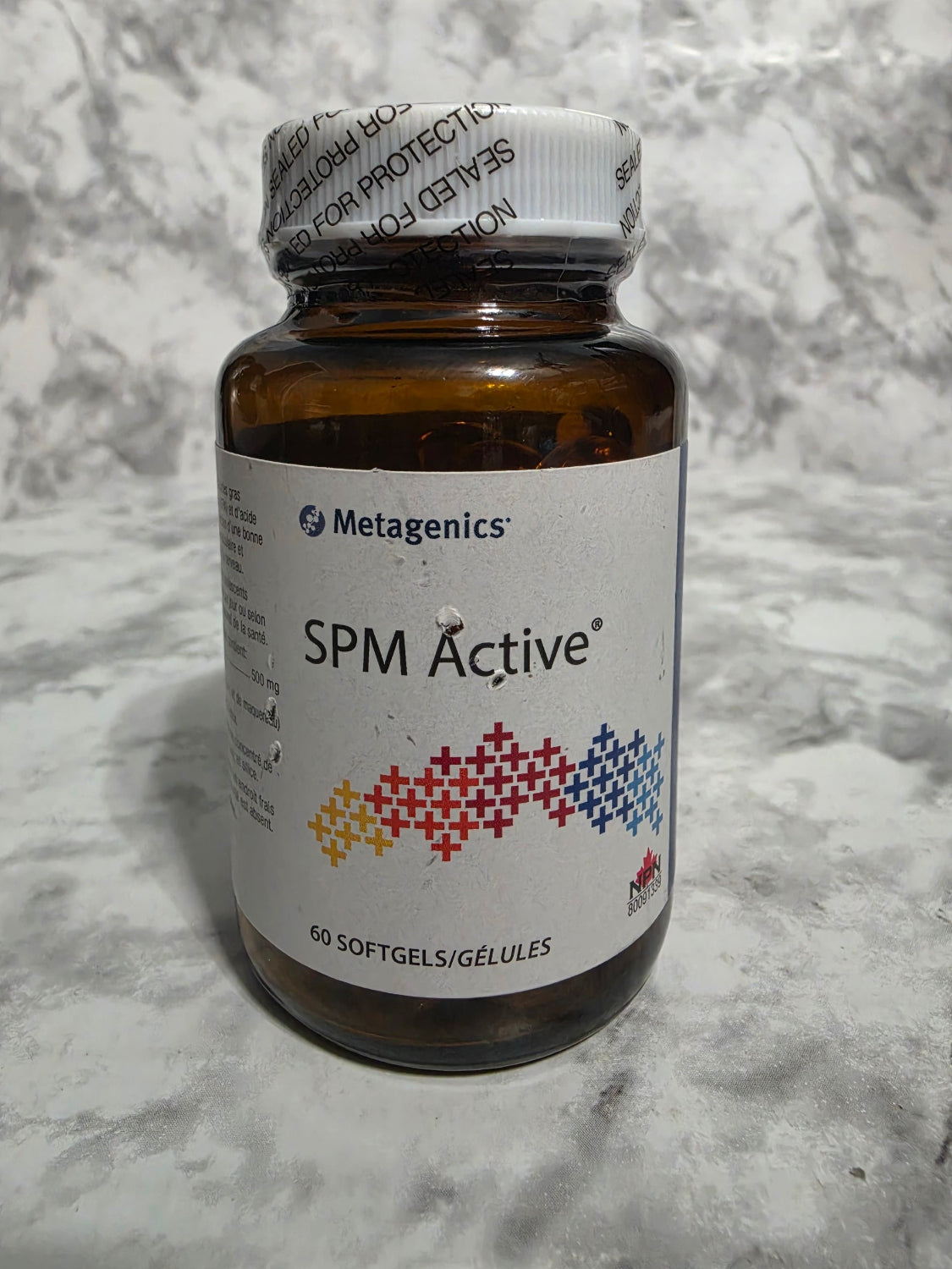 Bottle of SPM Active supplement with Metagenics label on a marble surface