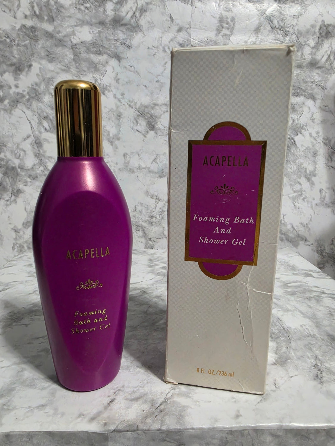 Purple bottle and box of Acorella on a marble surface