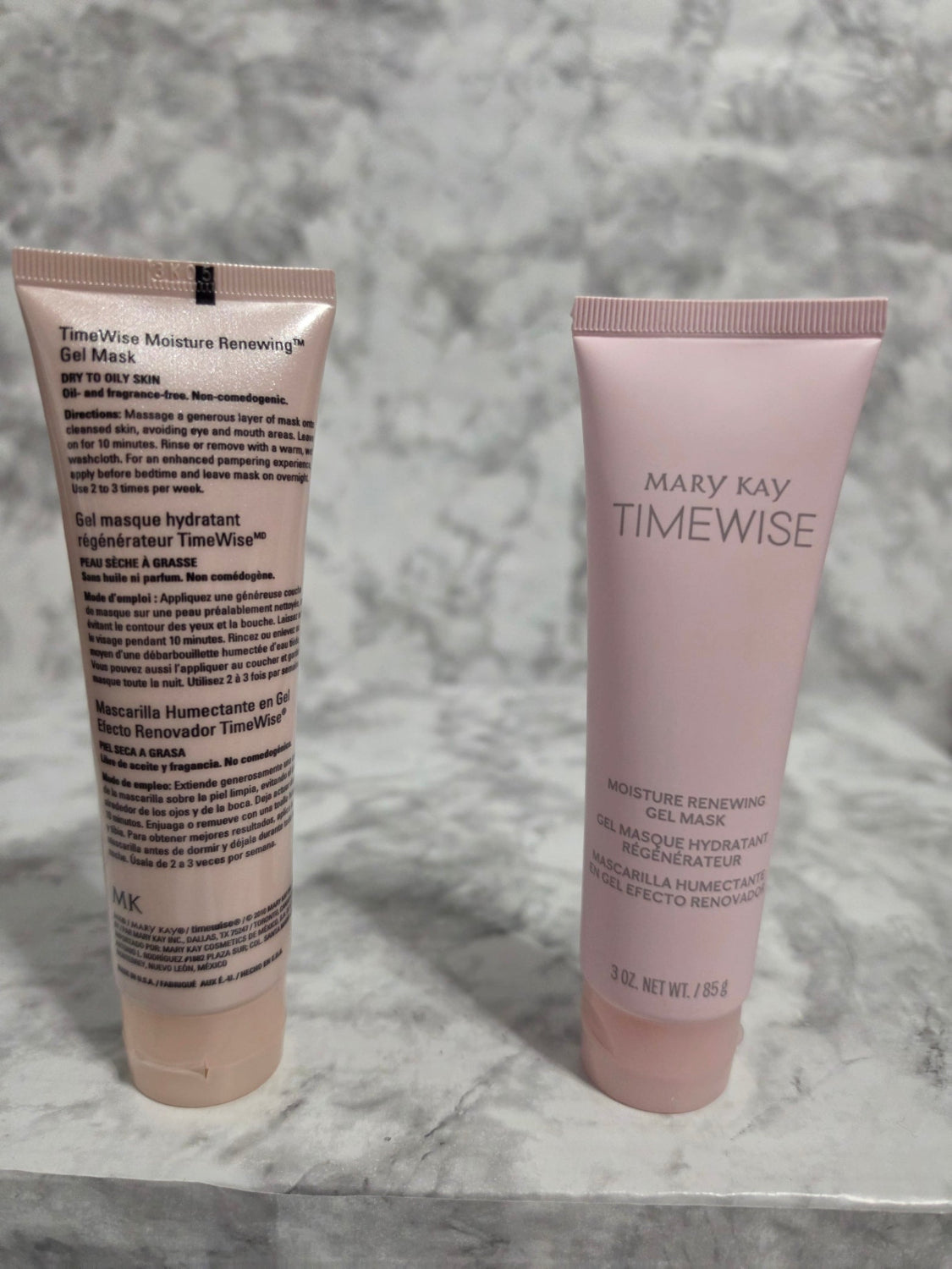 Two skincare tubes from Mary Kay on a marble surface