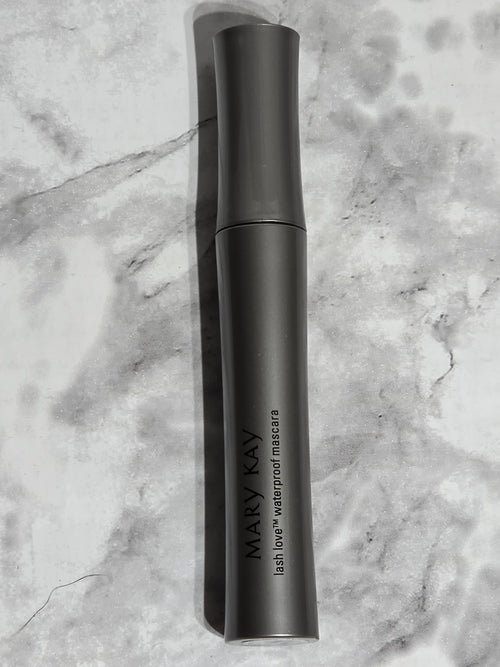 Black handheld device with 'MARY KAY' branding on a marble surface