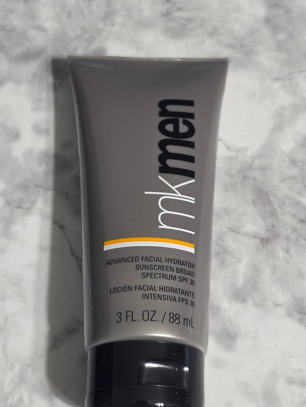 Tube of Men's Skin Care Lotion on a marble surface