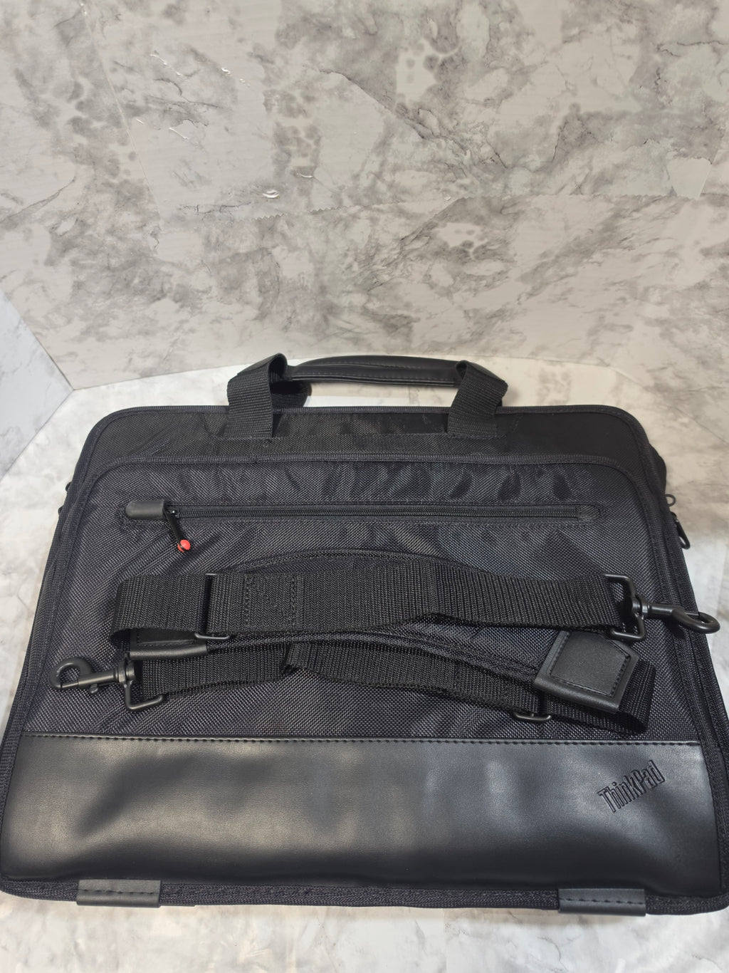 Black briefcase with straps on a gray surface