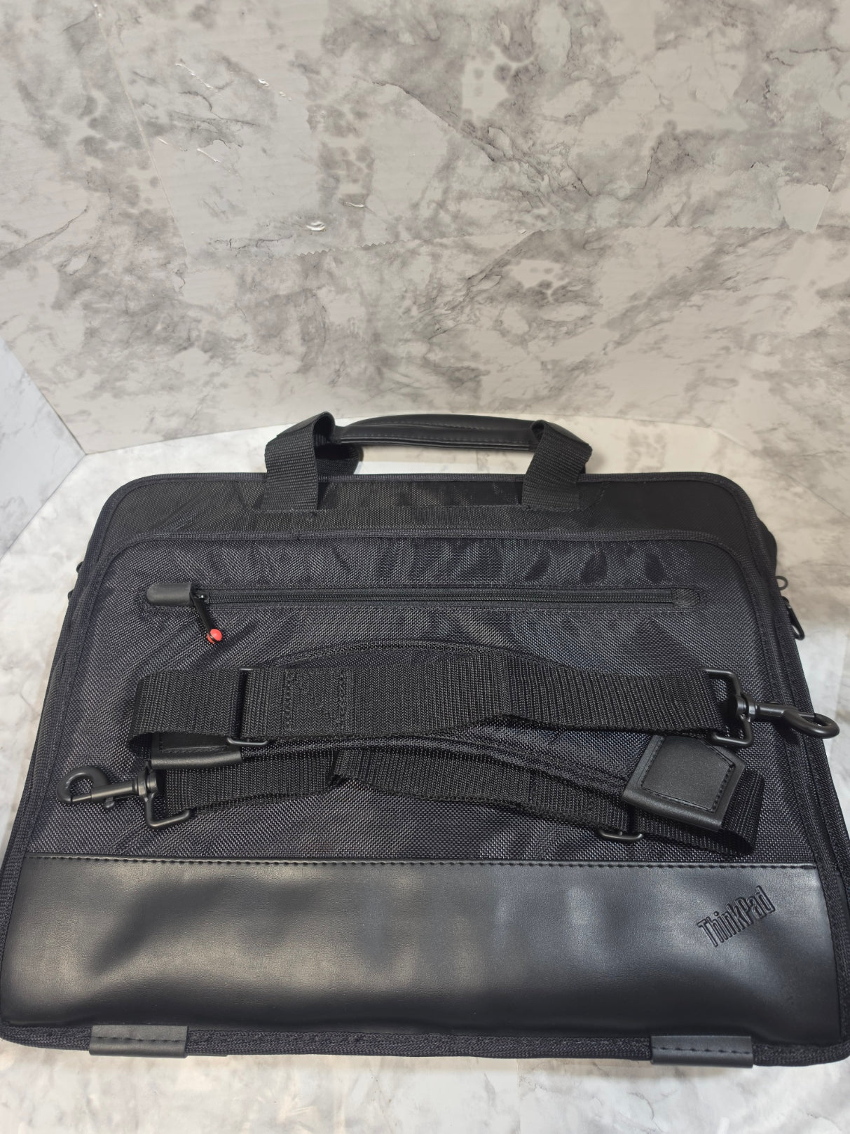 Black briefcase with straps on a gray surface
