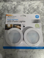 GE LED puck lights packaging on a marble surface