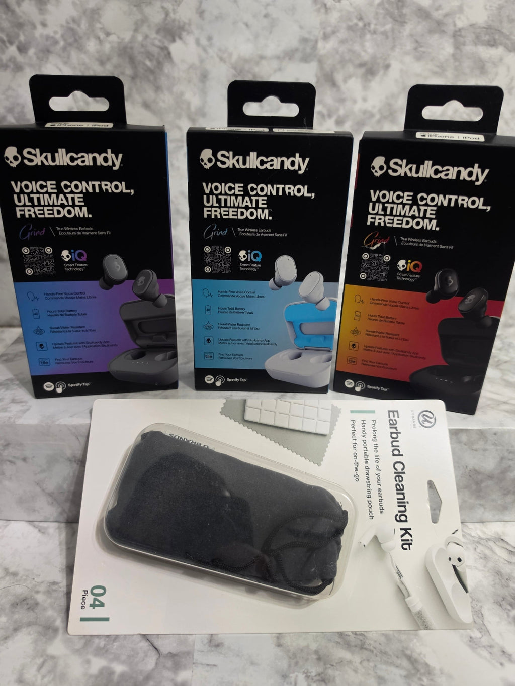 Skullcandy earbud packaging and earbud cleaning kit on a marble surface