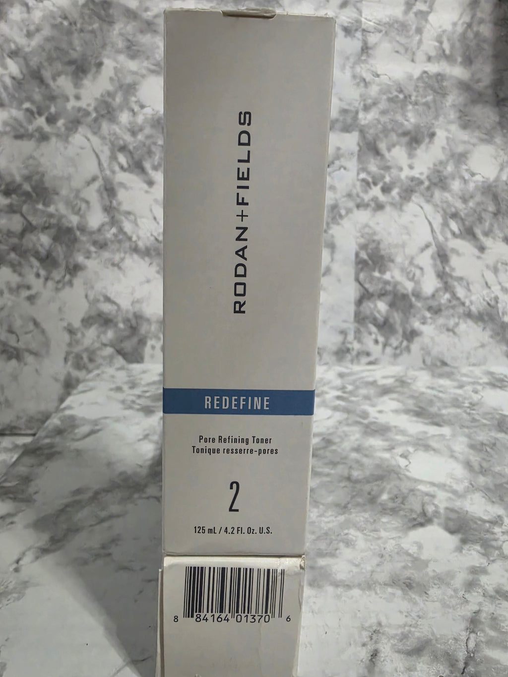 Rodan + Fields product packaging on a marble surface