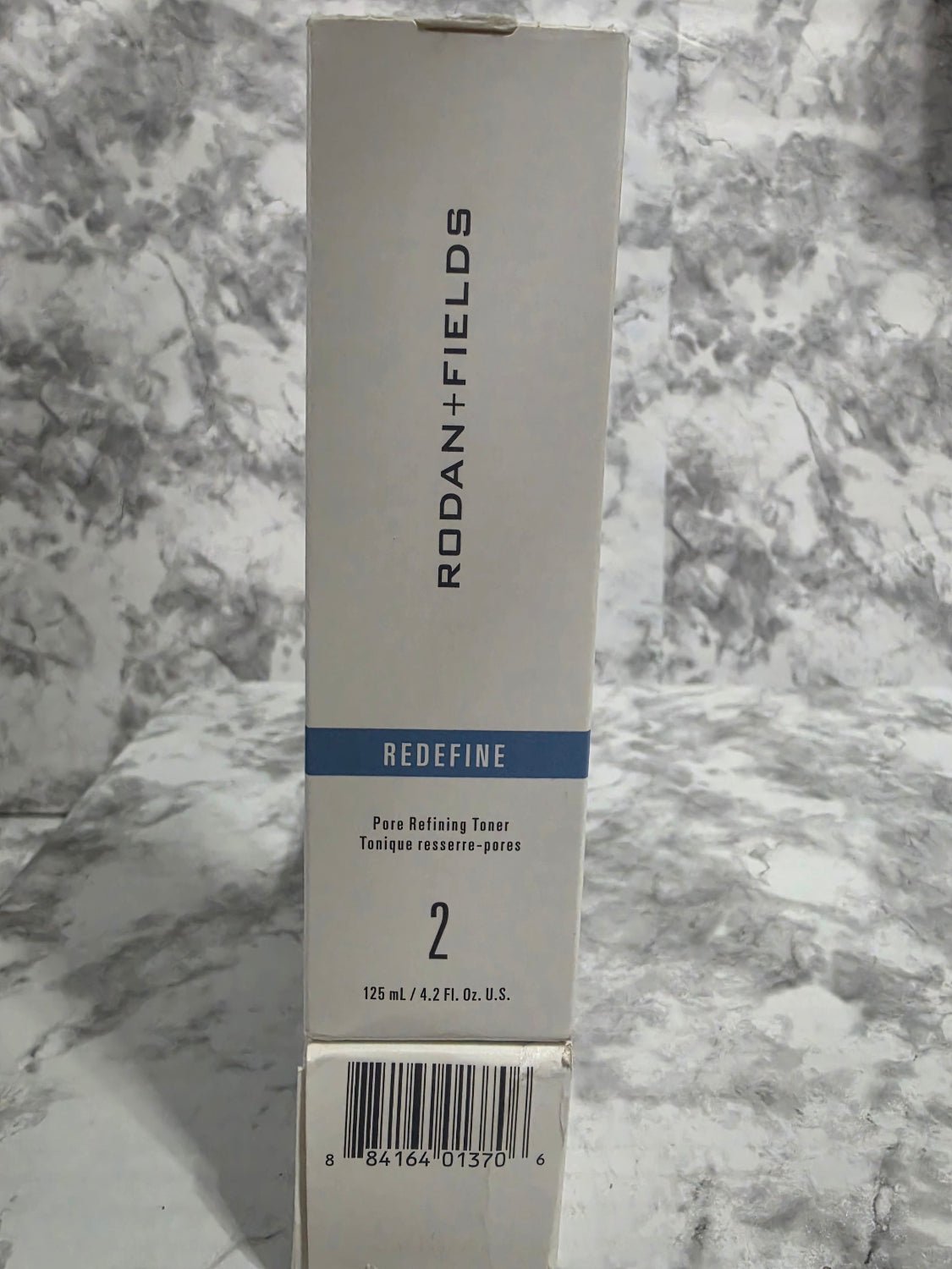 Rodan + Fields product packaging on a marble surface