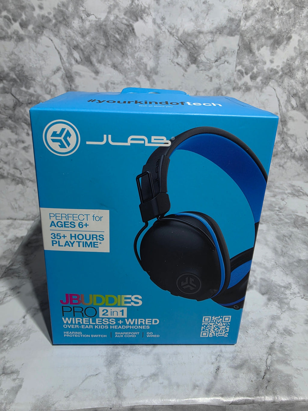 Blue JLab headphones packaging on a marble surface