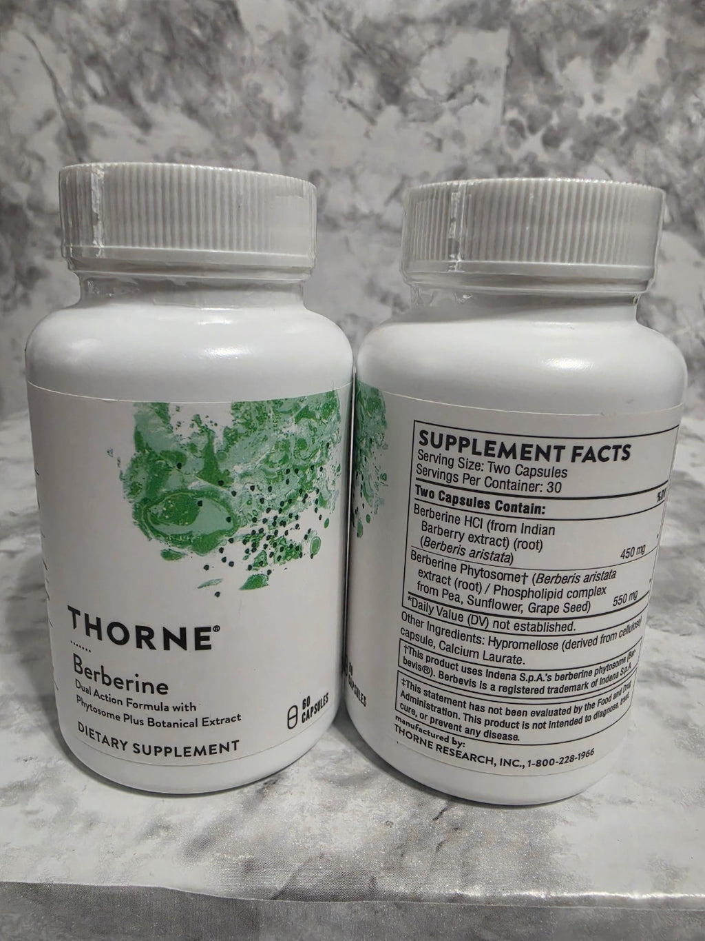 Two supplement bottles labeled 'Thorne' on a marble surface