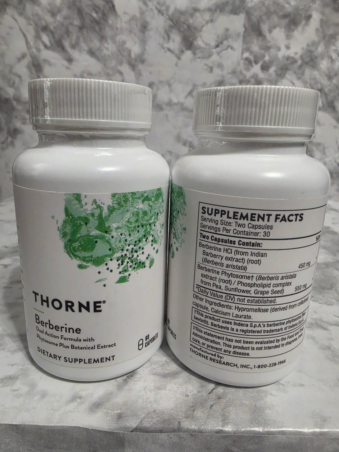 Two supplement bottles labeled 'Thorne' on a marble surface
