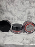 Two makeup containers with visible brand names on a marble surface