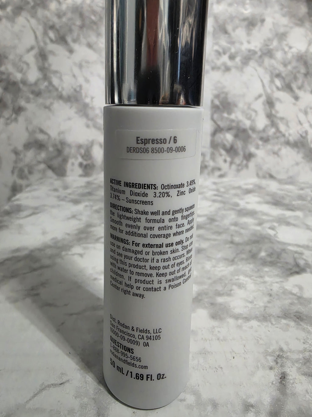 Cosmetic tube with label on a marble surface