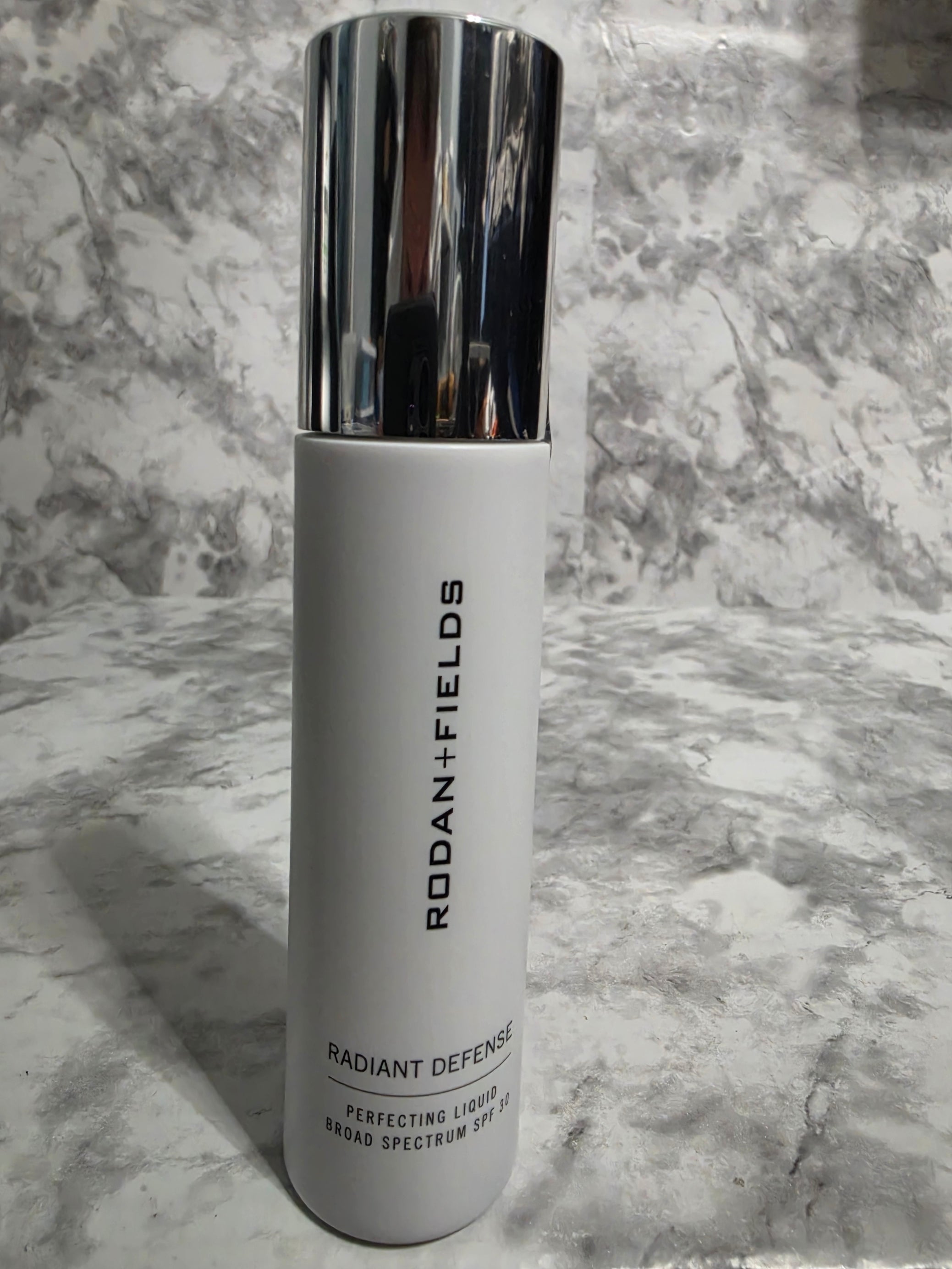Skincare product with 'Rodan + Fields' branding on a marble surface