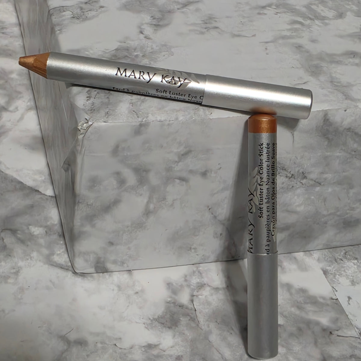 Mary Kay Soft Luster Eye Color Stick Bronze Gold shade pencils on marble