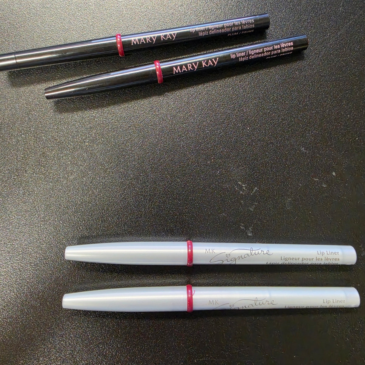 Mary Kay Plum lip liners in black and silver barrel editions.