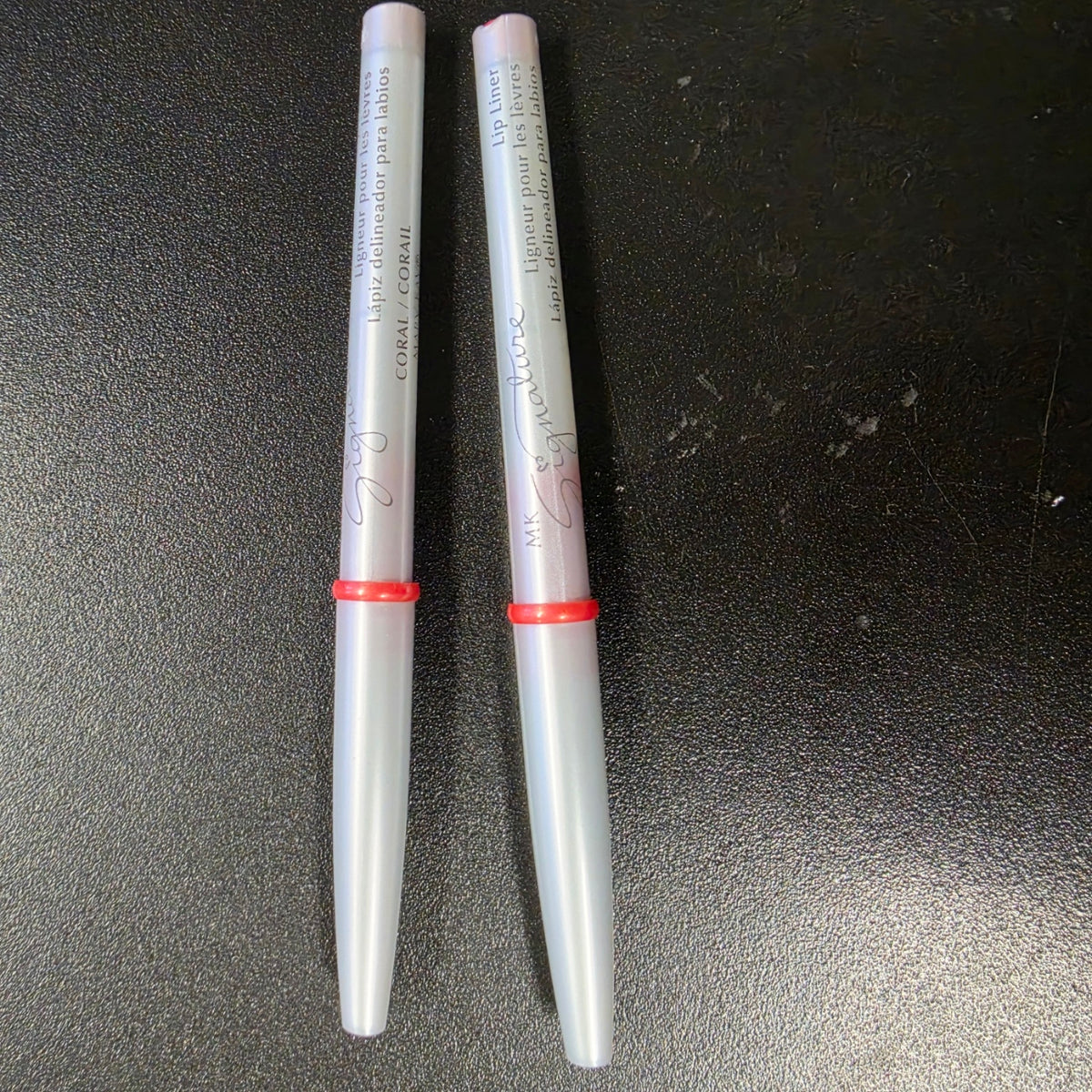 Mary Kay Signature Coral lip liners with silver barrels, front view.
