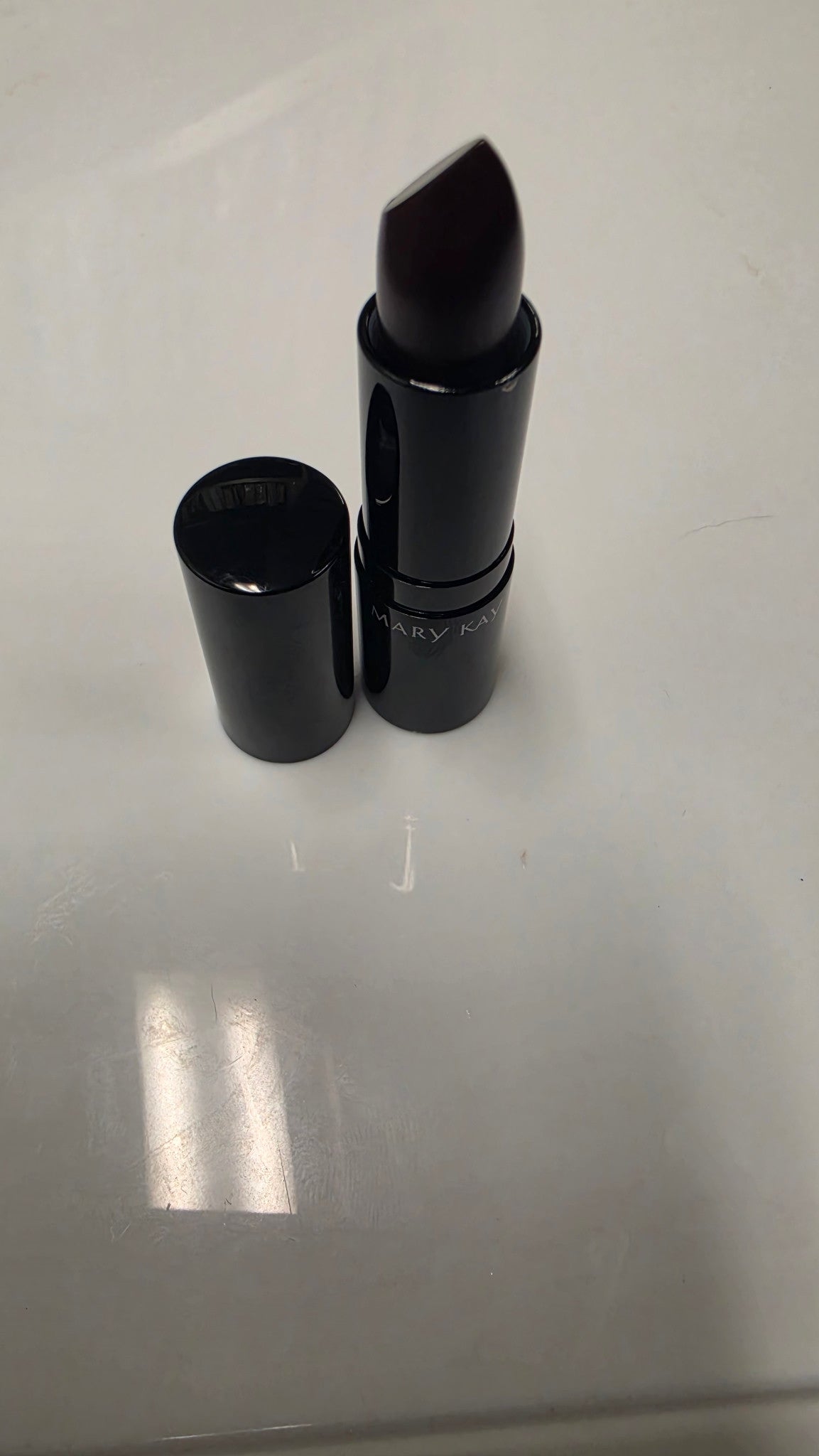 Mary Kay Puro Mirtillo matte lipstick with its cap beside it