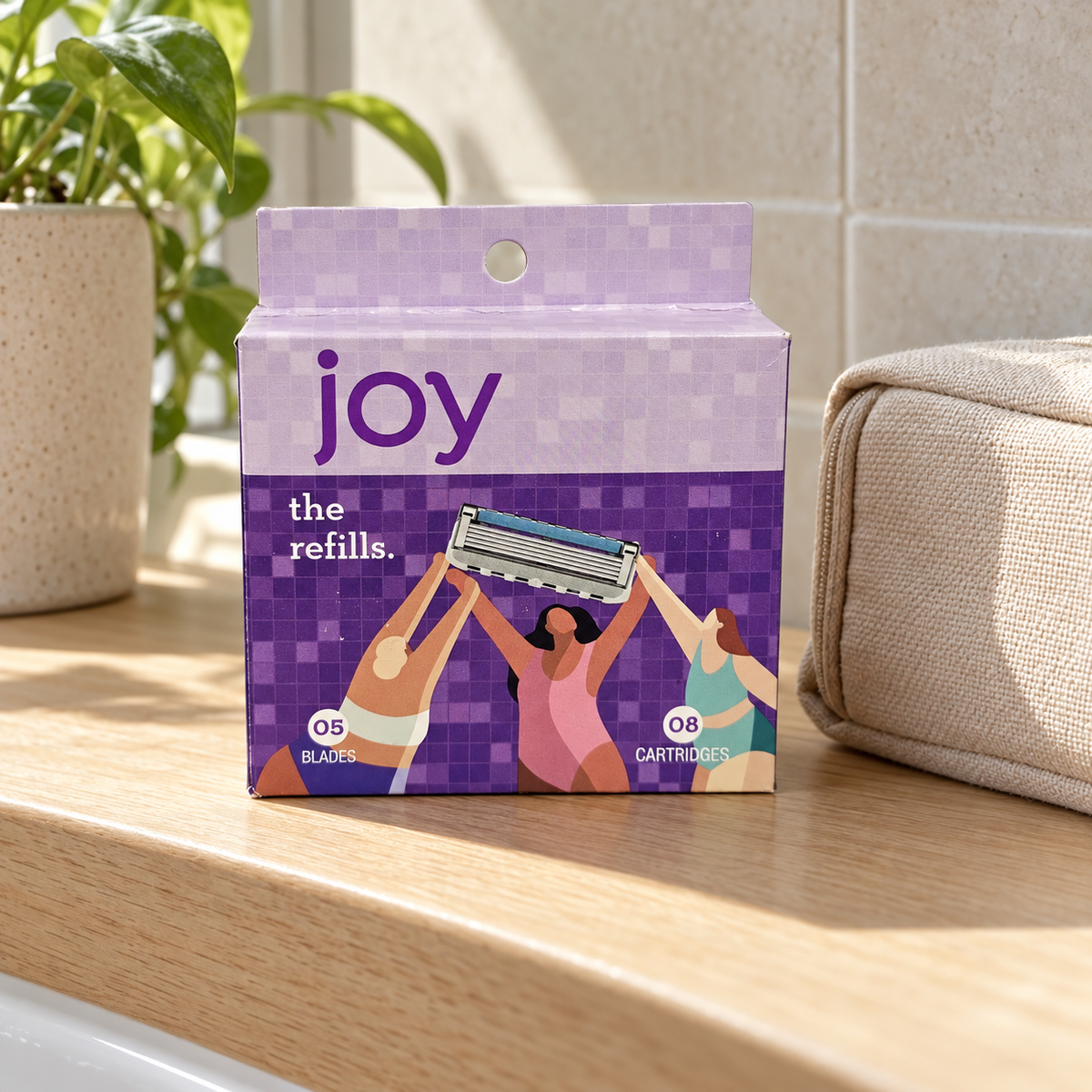 Joy eight-cartridge refill box on an oak ledge beside a toiletry pouch