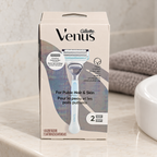 Gillette Venus Pubic Hair & Skin kit with one handle and two cartridges on a bathroom vanity beside a sink