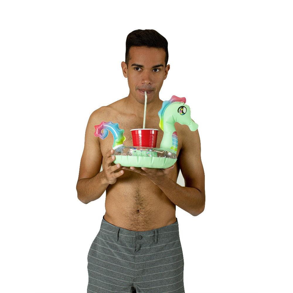 Adult holding the matching PoolCandy seahorse drink float with one cup in its center