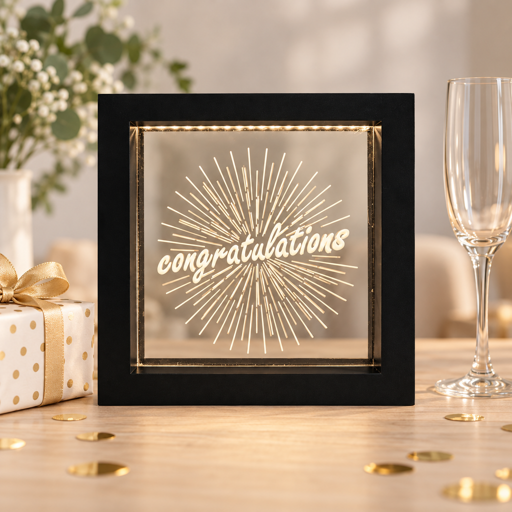 Black Congratulations LED light box on a celebration table with a gift and confetti