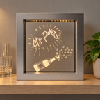 Silver Let's Party LED light box on a home bar shelf beside glasses and a plant