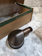 Bronze-colored light bulb on a cardboard box with a textured white background