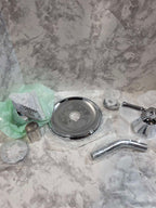 Set of bathroom fixtures including a shower head, drain cover, and faucet on a marble countertop.