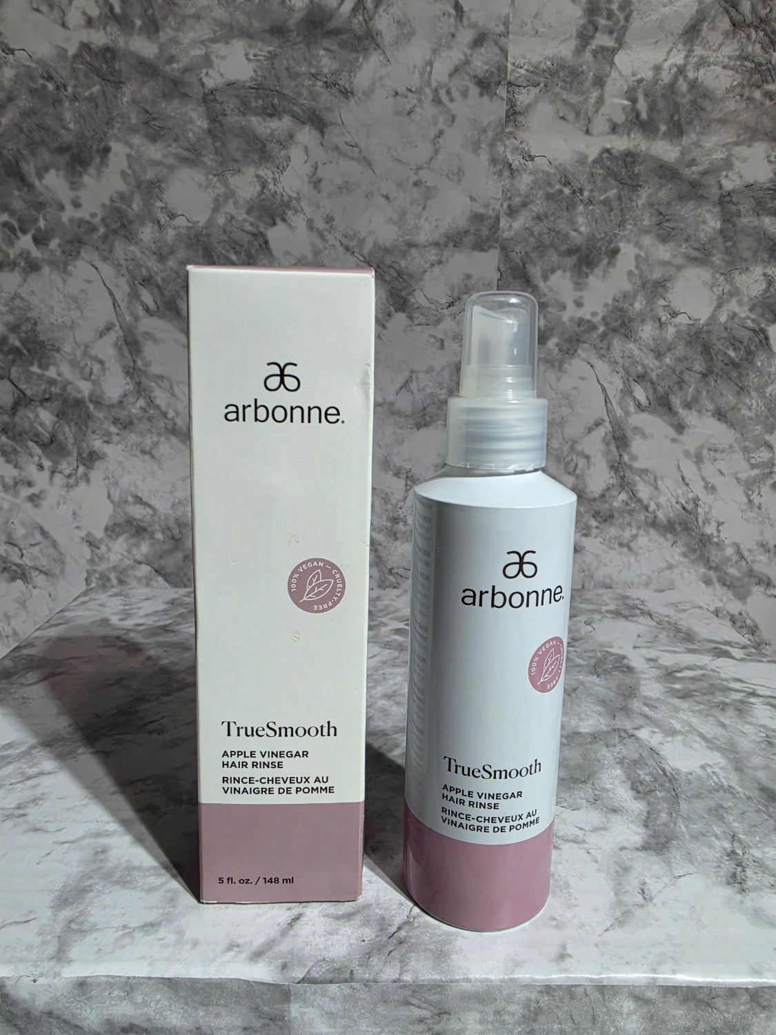 Arbonne TrueSmile skincare product and packaging on a marble surface