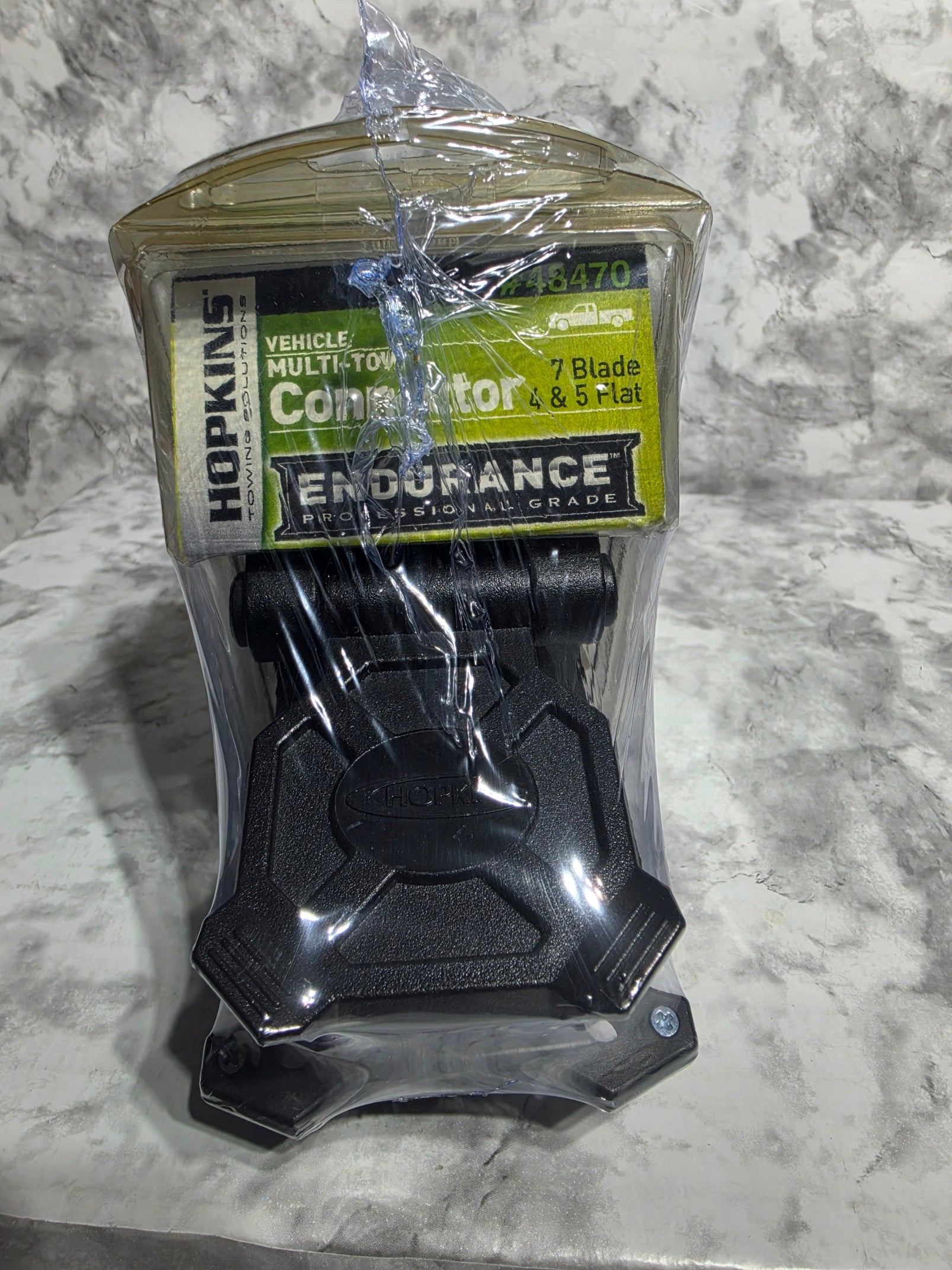 Black automotive connector with packaging on a gray surface