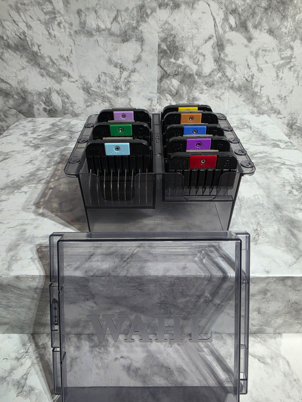Black printer cartridge holder with colorful cartridges on a marble surface