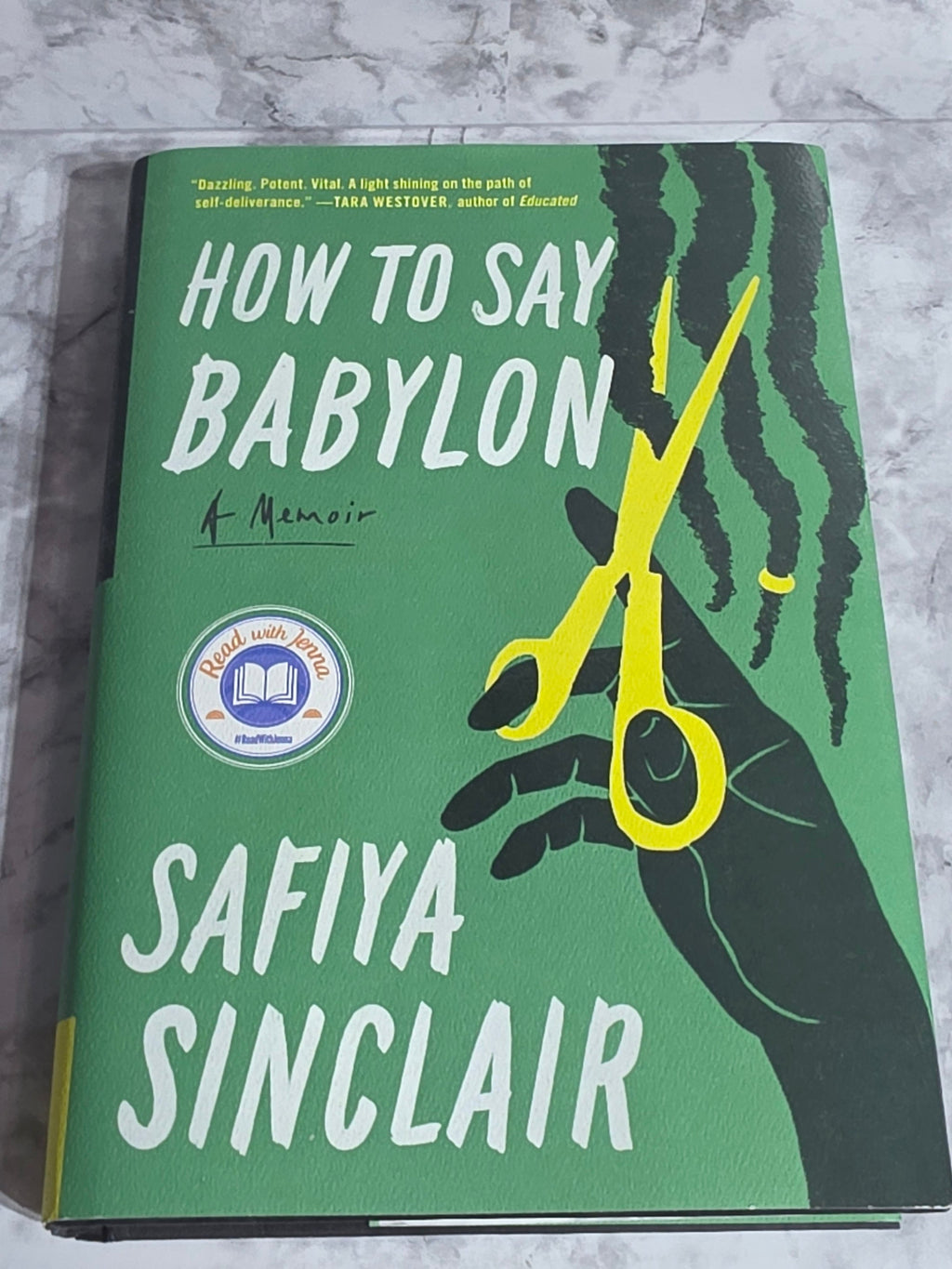 Book cover of 'How to Say Babylon' by Safiya Sinclair on a textured surface