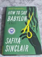 Book cover of 'How to Say Babylon' by Safiya Sinclair on a textured surface