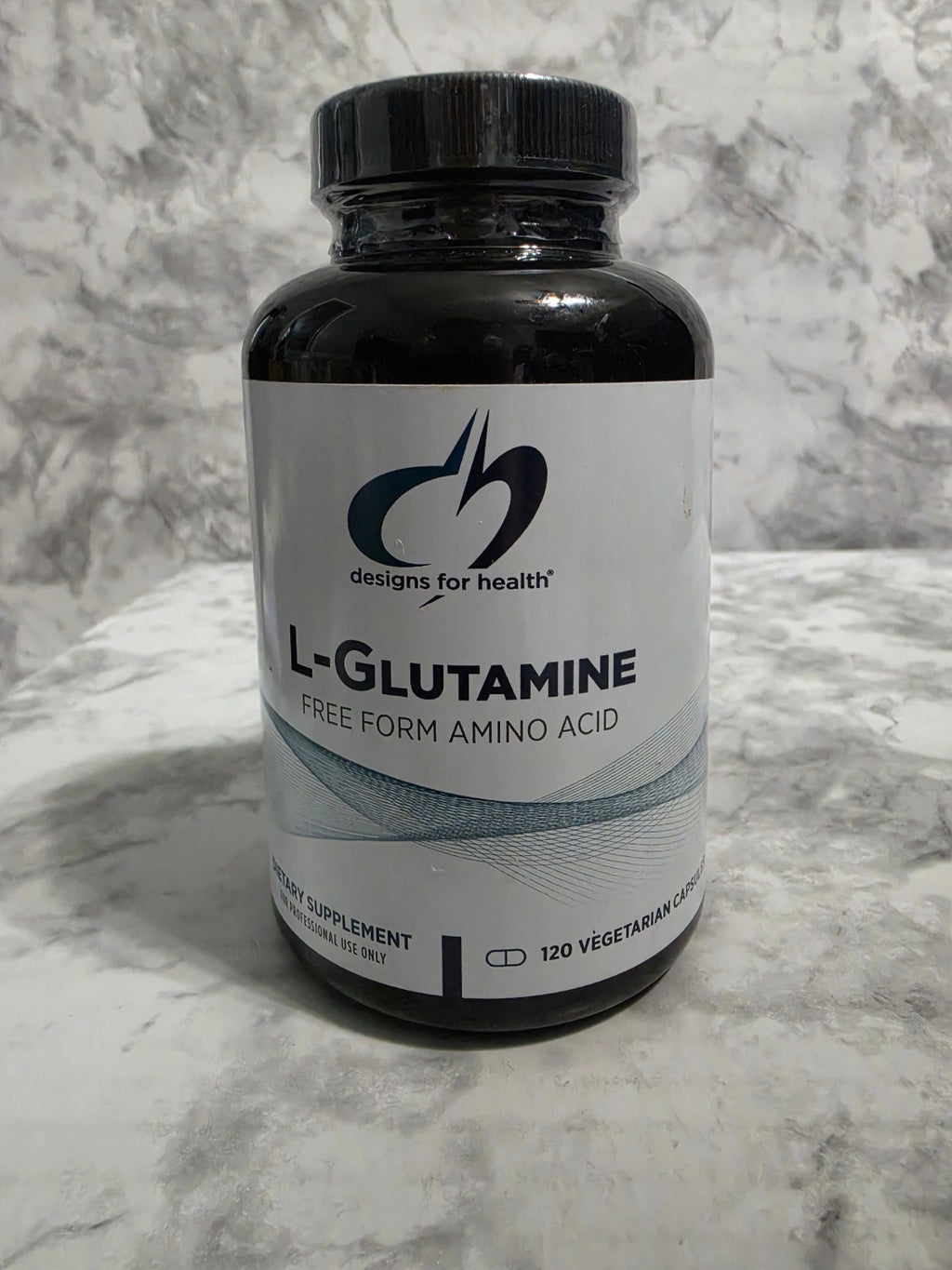 Bottle of L-Glutamine supplement on a marble surface