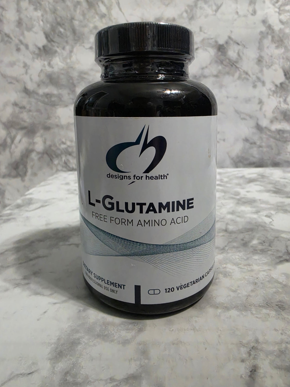 Bottle of L-Glutamine supplement on a marble surface