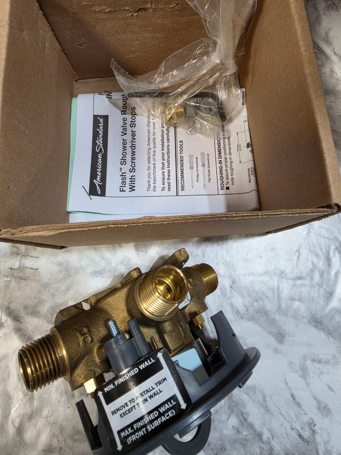 Brass valve and packaging with instructions on a textured surface