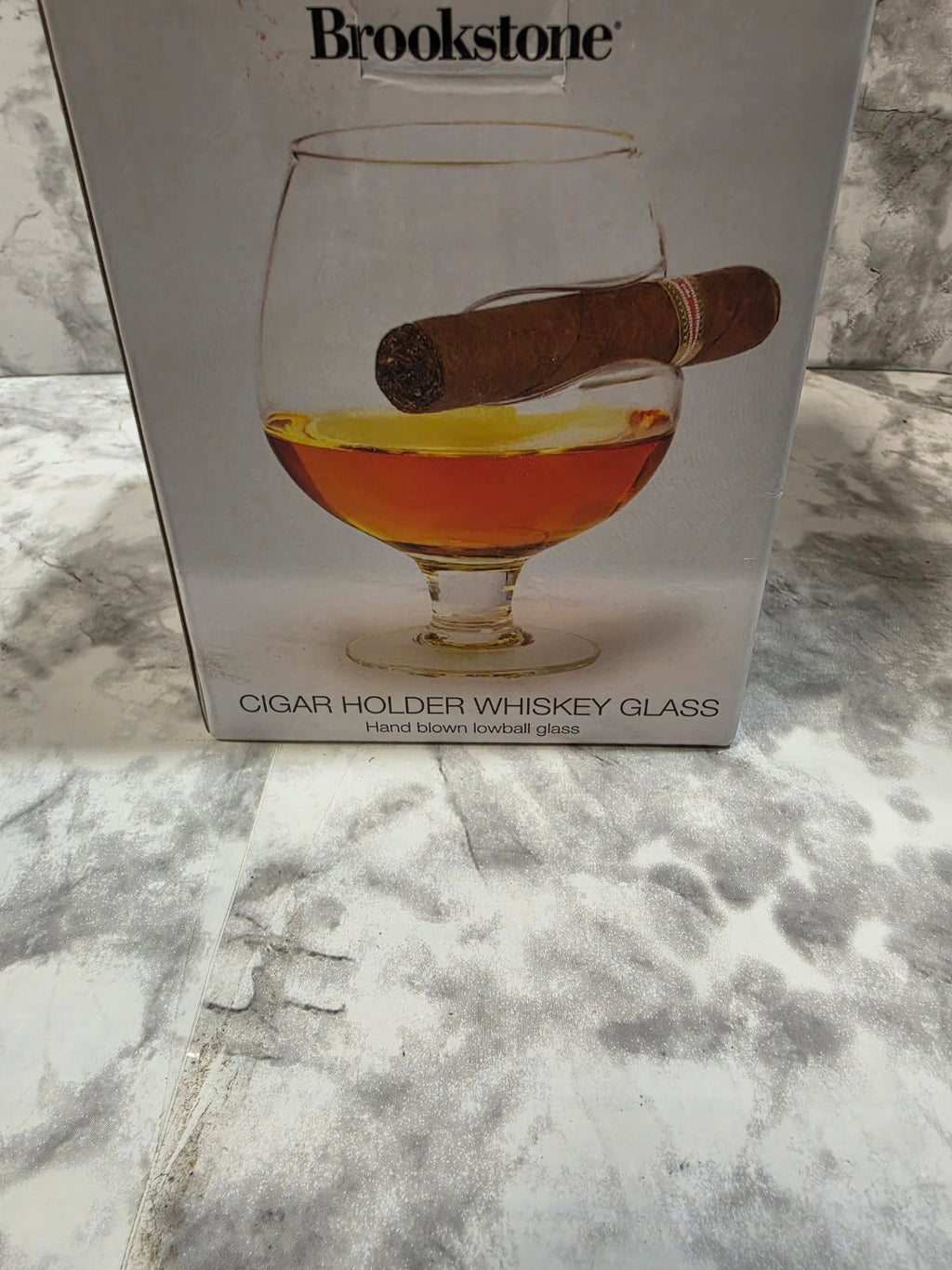 Brookstone cigar holder whiskey glass packaging on a marble surface