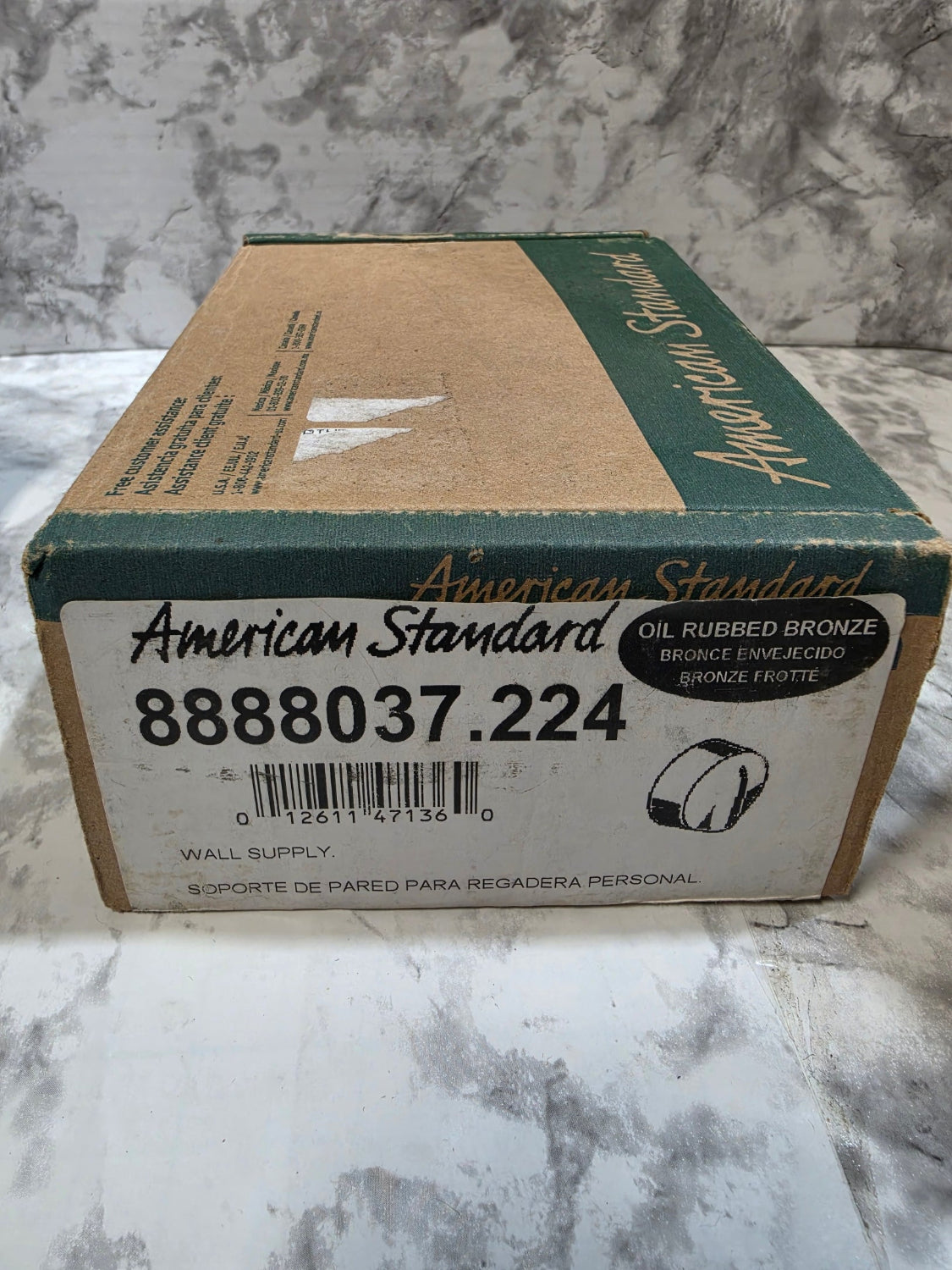 Cardboard box with American Standard branding on a marble surface