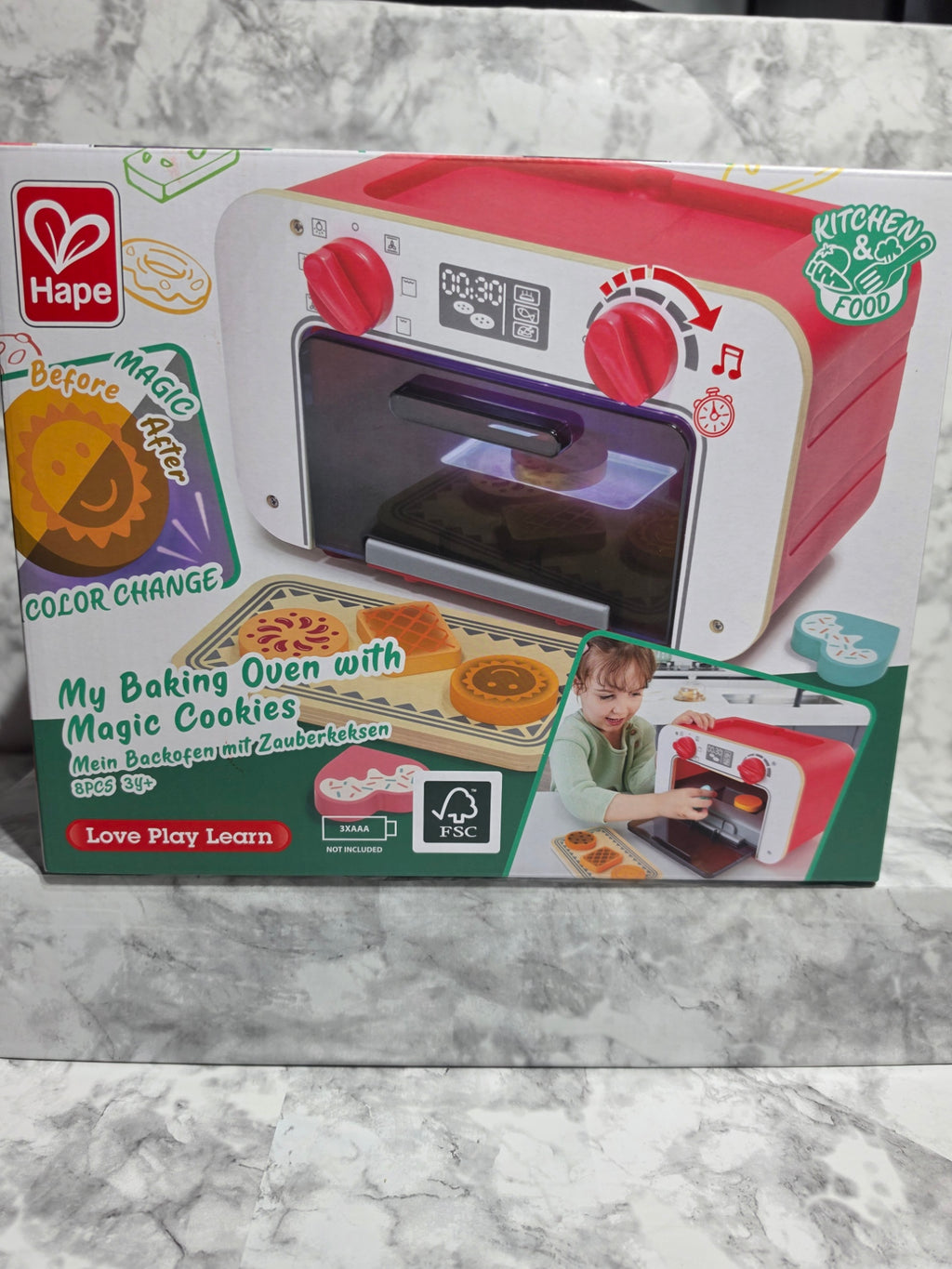 Children's toy oven packaging on a marble surface