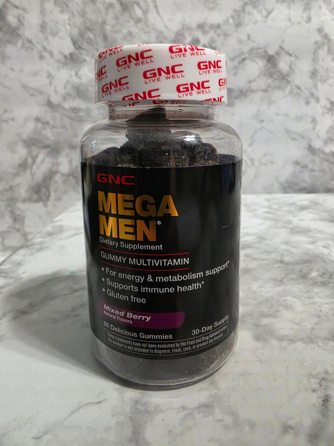 GNC Mega Men supplement bottle on a marble surface