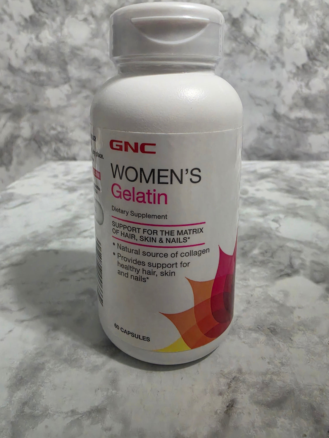 GNC Women's Gelatin bottle on a marble surface
