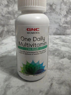 GNC Women's One Daily Multivitamin bottle on a marble surface