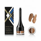 Mary Kay Gel Liner Duo in a black bottle with a clear base showing the dual shades, next to its black, white, blue, and gold box, with two swatches of the beige and brown gel liner shades on the right.