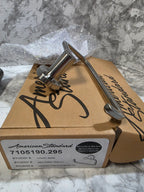 Metal bottle opener attached to a cardboard box with branding on a marble surface