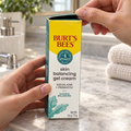 AI-generated illustration: adult hands lifting the top flap of the Burt’s Bees Skin Balancing Gel Cream 1.8 oz carton, with contents concealed.