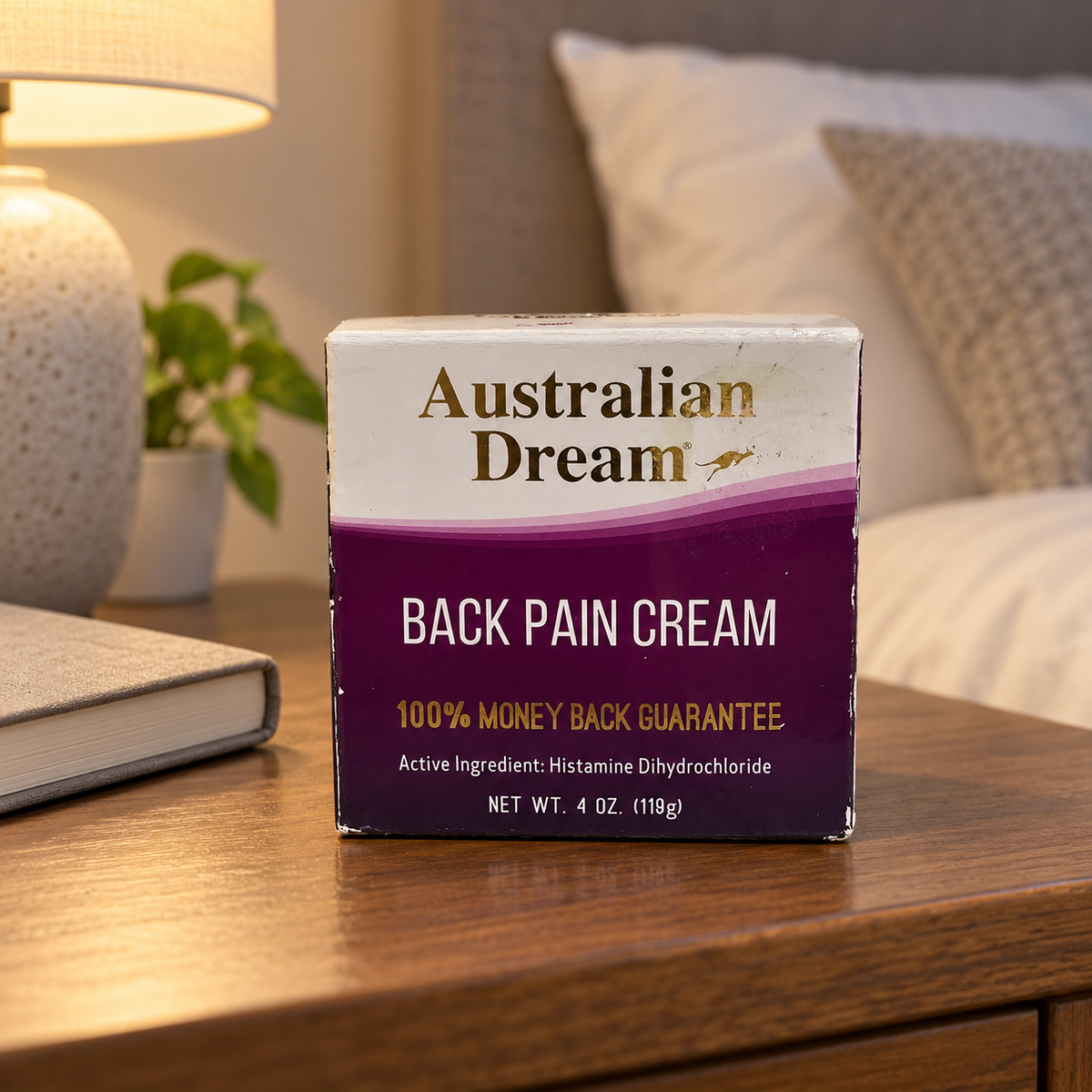 AI-generated lifestyle illustration: closed Australian Dream Back Pain Cream 4 oz carton on a bedside table; furnishings and book are props, not included.